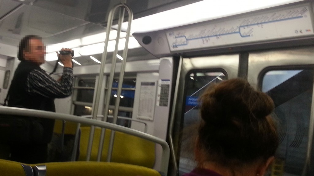 Un homme dans le RER B en train de filmer le plan de ligne.