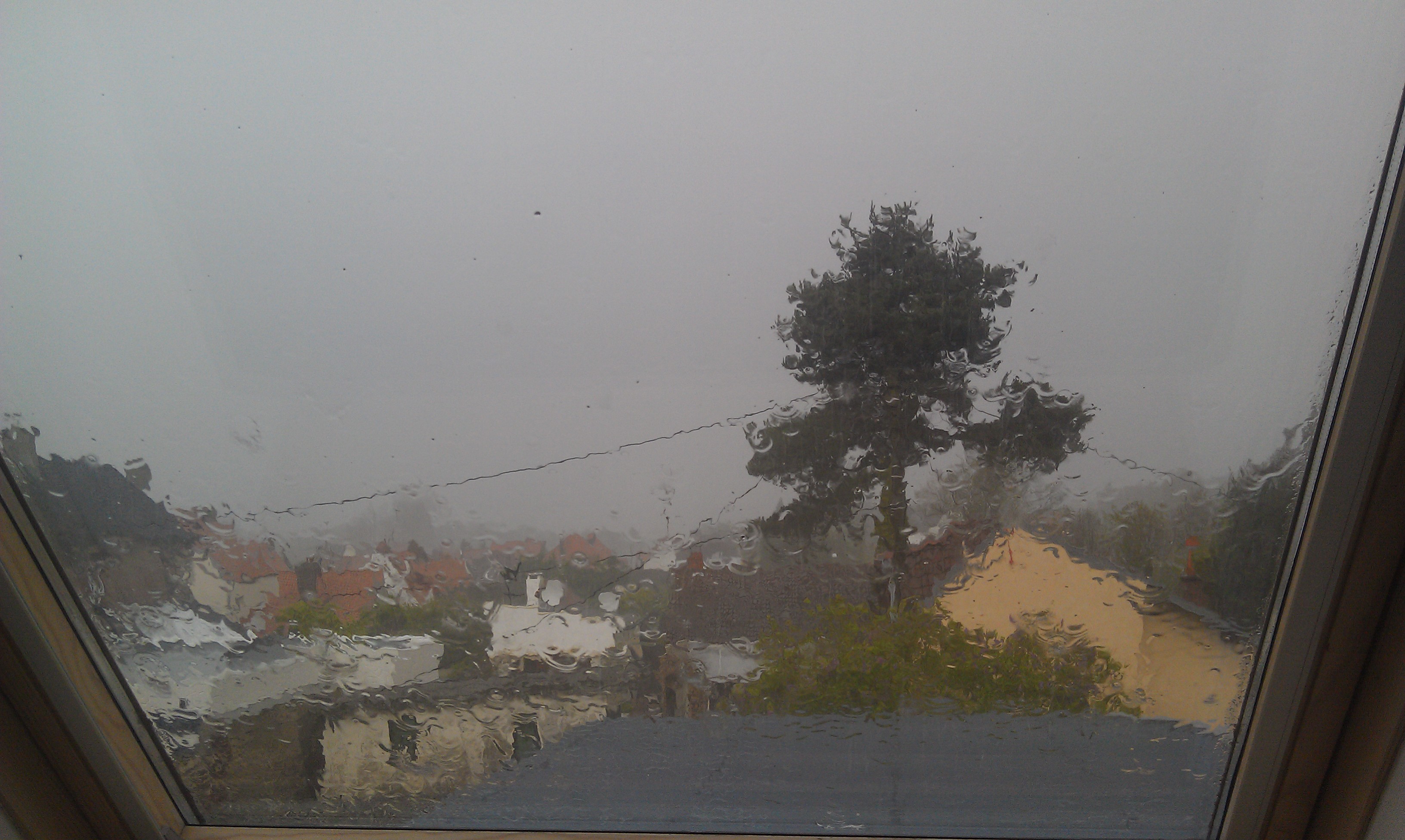 La vue sur le village, depuis la fenêtre de ma chambre, à travers un rideau de pluie.