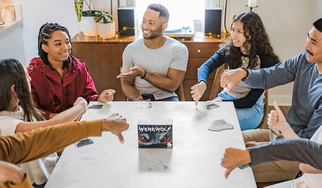 7 personnes autour d'une table votent, surtout des pouces vers le bas